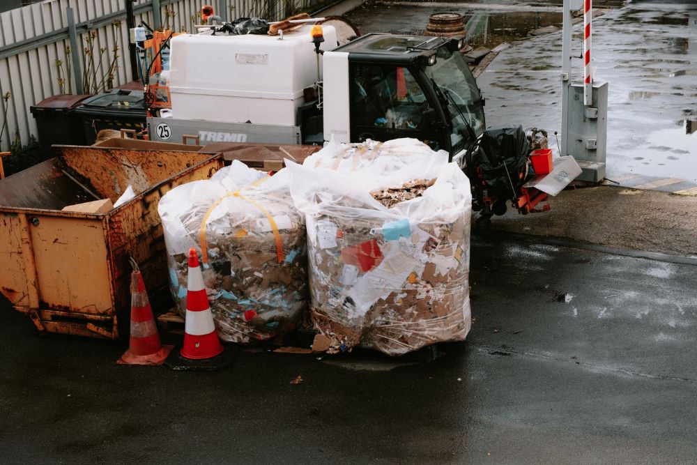 A garbage truck stands next to a fence, highlighting bulk junk removal services available in Washington, DC.